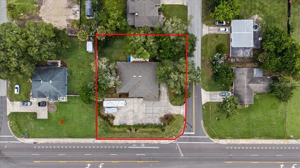 An aerial view of a light blue house with a large concrete driveway and RV — 1830 ORANGE TREE DRIVE, EDGEWATER, FL