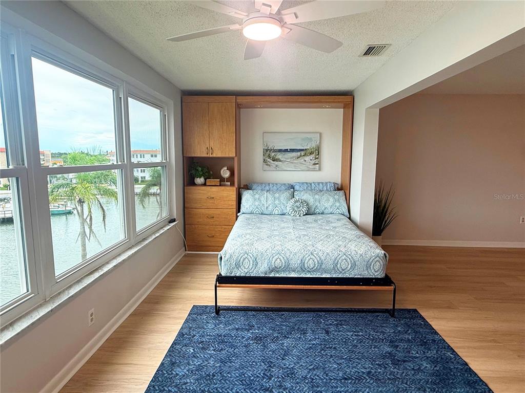An entryway features a blue front door with a floral wreath and a hallway runner — 5925 SHORE BOULEVARD S UNIT 405, GULFPORT, FL