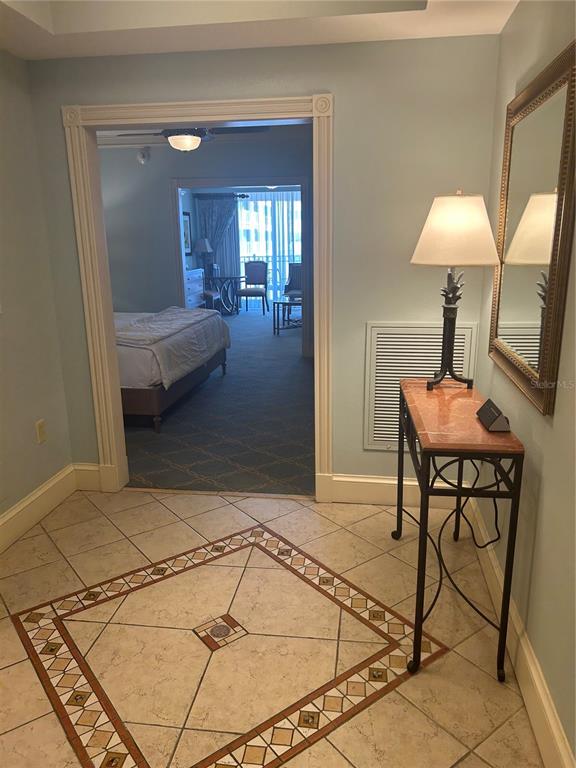 A tiled entryway leads through a doorway into a bedroom with a view of a balcony — 200 OCEAN CREST DRIVE UNIT 421, PALM COAST, FL