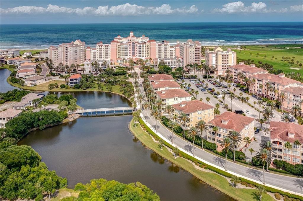 An aerial view of a large coastal resort complex with a lake and bridge — 200 OCEAN CREST DRIVE UNIT 421, PALM COAST, FL