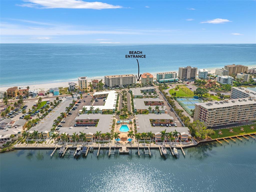 An aerial view shows a waterfront condominium complex with a pool and beach access — 19417 GULF BOULEVARD UNIT C106, INDIAN ROCKS BEACH, FL