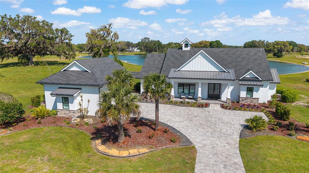 An aerial view of a white farmhouse with a dark roof and paved driveway — 12902 SW 138TH LOOP, DUNNELLON, FL