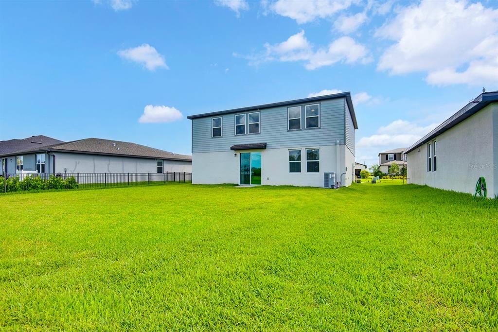 An aerial view of a two-story suburban house with a light blue exterior and driveway — 10025 DAYBREAK GLEN, PARRISH, FL
