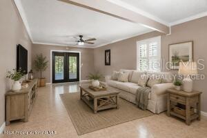 A living room features a beige sofa, a wooden coffee table, and French doors — 913 CANDLEBROOK LANE, BROOKSVILLE, FL