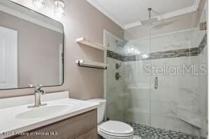 A bathroom features a vanity with a mirror, a toilet, and a glass-enclosed walk-in shower — 913 CANDLEBROOK LANE, BROOKSVILLE, FL
