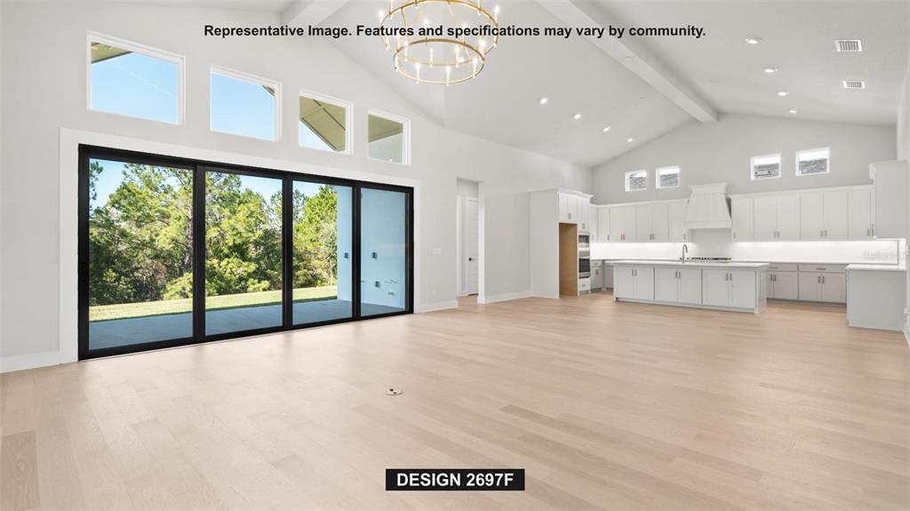 This rendering shows a spacious open-concept living area with light wood floors and white cabinetry — 4976 ELM LEAF DRIVE, BROOKSVILLE, FL