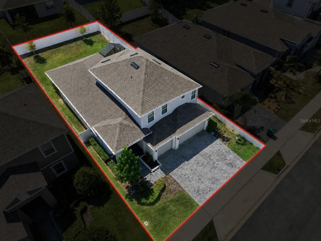 An aerial view of a two-story house with a paved driveway and a fenced backyard — 2463 NATOMA BOULEVARD, MOUNT DORA, FL