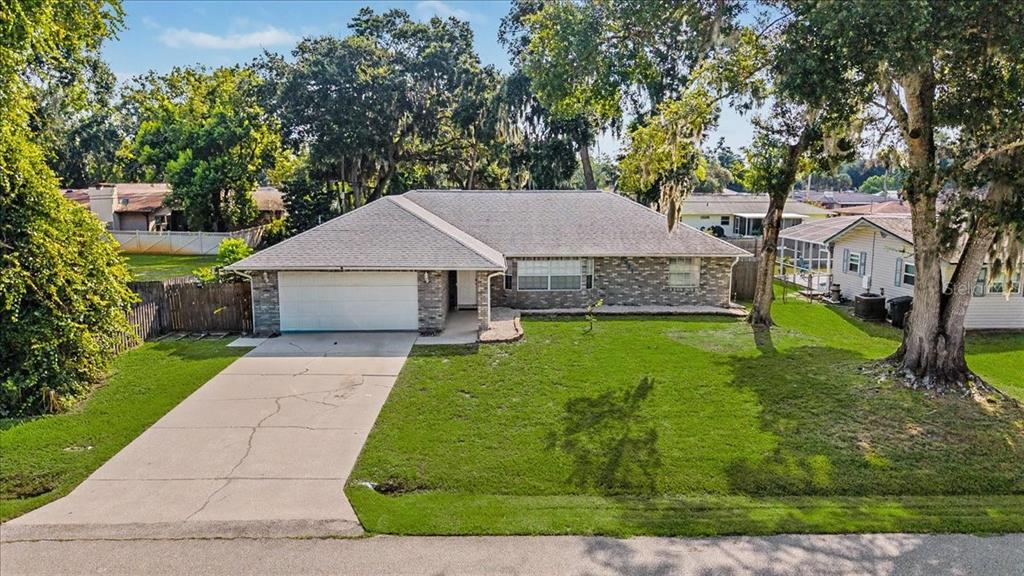 A single-story brick house with a two-car garage and a concrete driveway — 2311 PINE TREE, EDGEWATER, FL