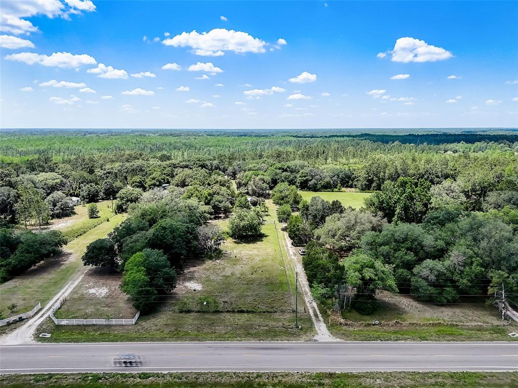 An aerial view shows a rectangular plot of land bordered by a road and trees — 7119 STATE ROAD 33, CLERMONT, FL