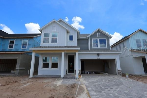 A two-story house exterior features a front porch, a garage, and mixed siding materials — 2786 SOLETA VIEW, ODESSA, FL
