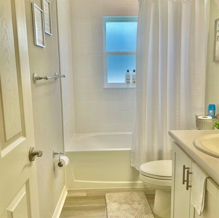 A bathroom features a white tub-shower combination, a toilet, and a vanity with a sink — 315 LILY LANE, DAVENPORT, FL