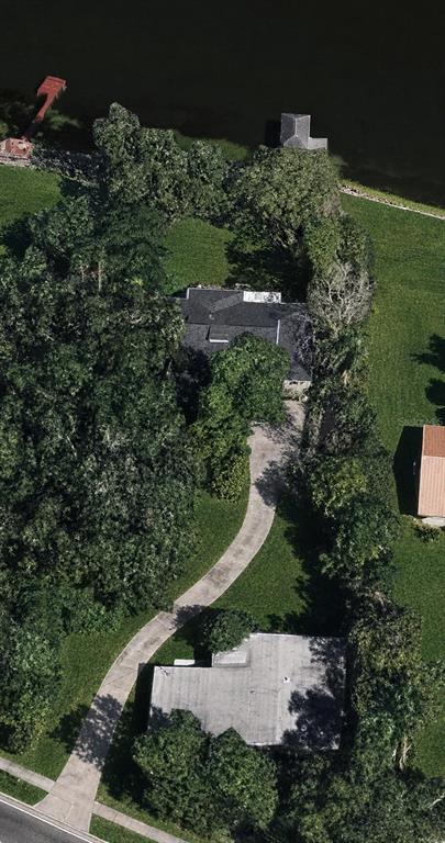 A wooden deck overlooks a lake with a dock, large trees, and a flower planter — 2510 CYPRESS GARDENS BOULEVARD, WINTER HAVEN, FL