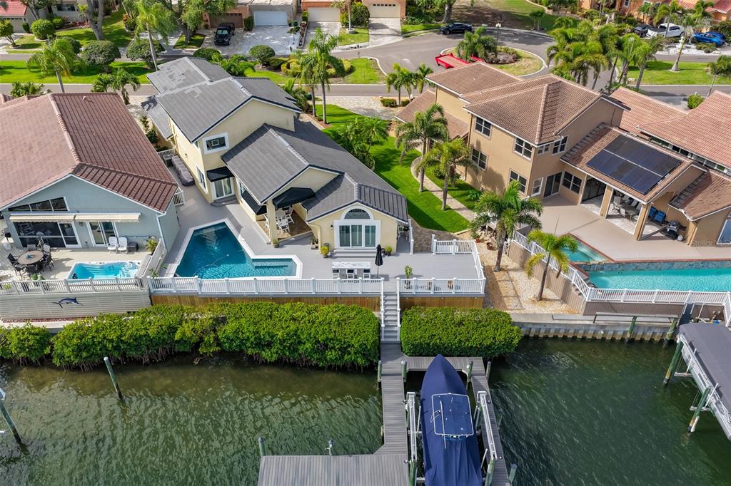 An aerial view shows waterfront houses with pools, decks, and a private boat dock — 831 SYMPHONY ISLES BOULEVARD, APOLLO BEACH, FL