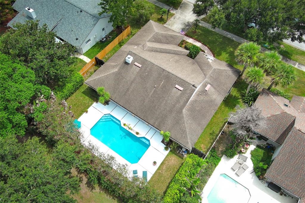 An aerial view shows a house with a shingled roof, a swimming pool, and landscaping — 4661 N SAINT BRIDES CIRCLE, ORLANDO, FL