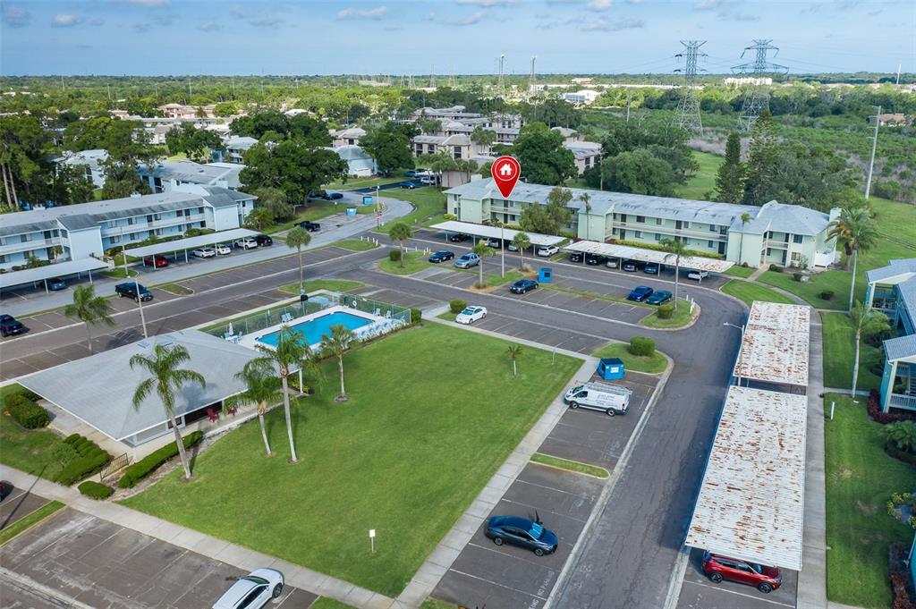 An aerial view shows a multi-story apartment complex with a swimming pool and parking lot — 130 NANCY DRIVE UNIT 37, OLDSMAR, FL