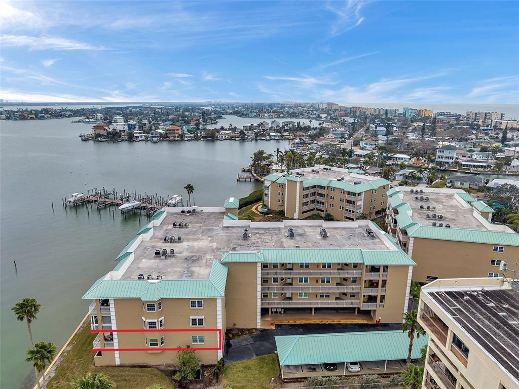 An aerial view of a multi-story waterfront apartment complex with a red-outlined unit — 399 150TH AVENUE UNIT 101, MADEIRA BEACH, FL