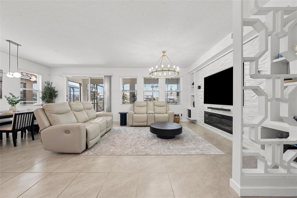 A living room features light-colored leather sofas, a fireplace, and a decorative white room divider — 7552 OAKMOSS LOOP, DAVENPORT, FL