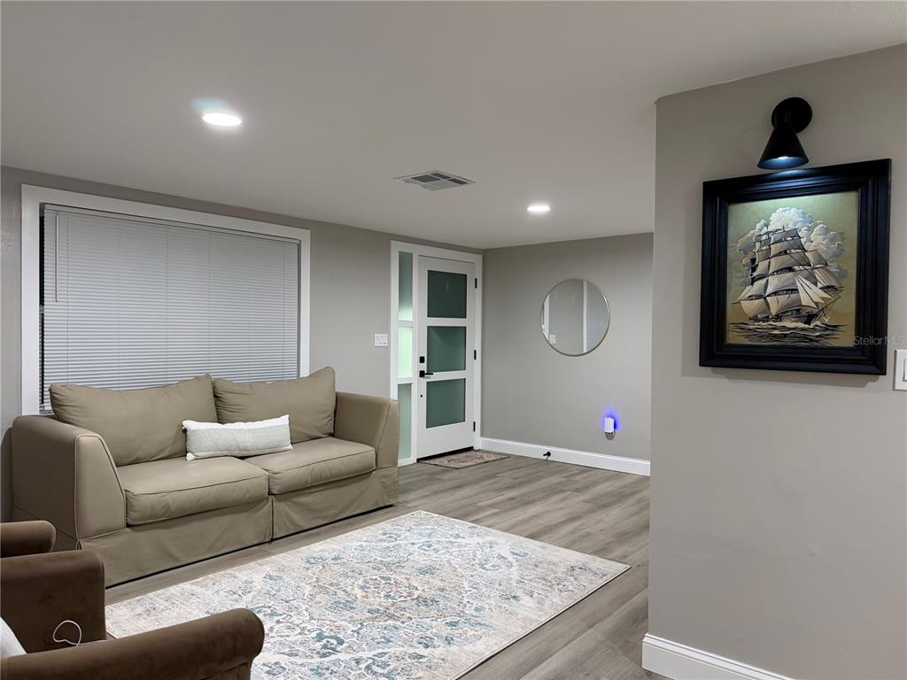 An interior view of a room with gray walls, wood-look flooring, and white trim — 7220 FOX HOLLOW DRIVE, PORT RICHEY, FL