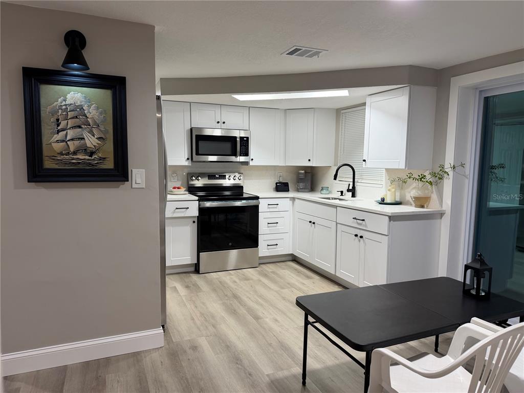 A bedroom with gray walls, wood-look flooring, and white bi-fold closet doors — 7220 FOX HOLLOW DRIVE, PORT RICHEY, FL