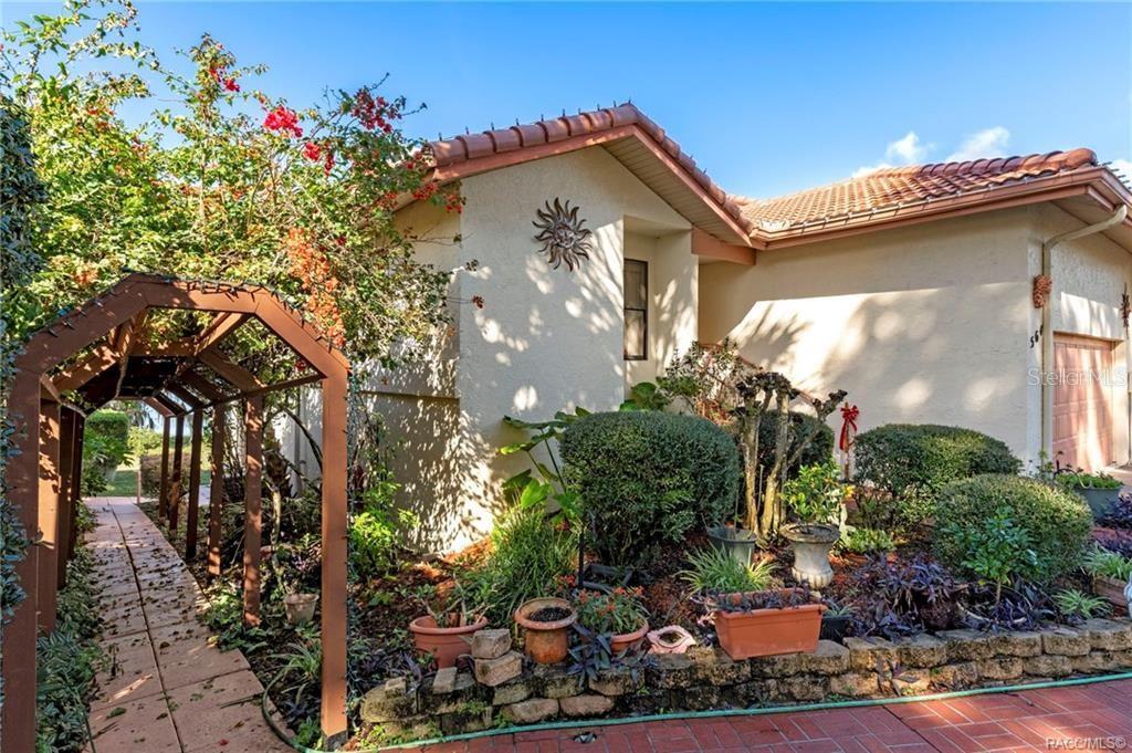 A single-story house with a terracotta tile roof, stucco exterior, and a brick walkway — 564 SAN REMO CIRCLE, INVERNESS, FL