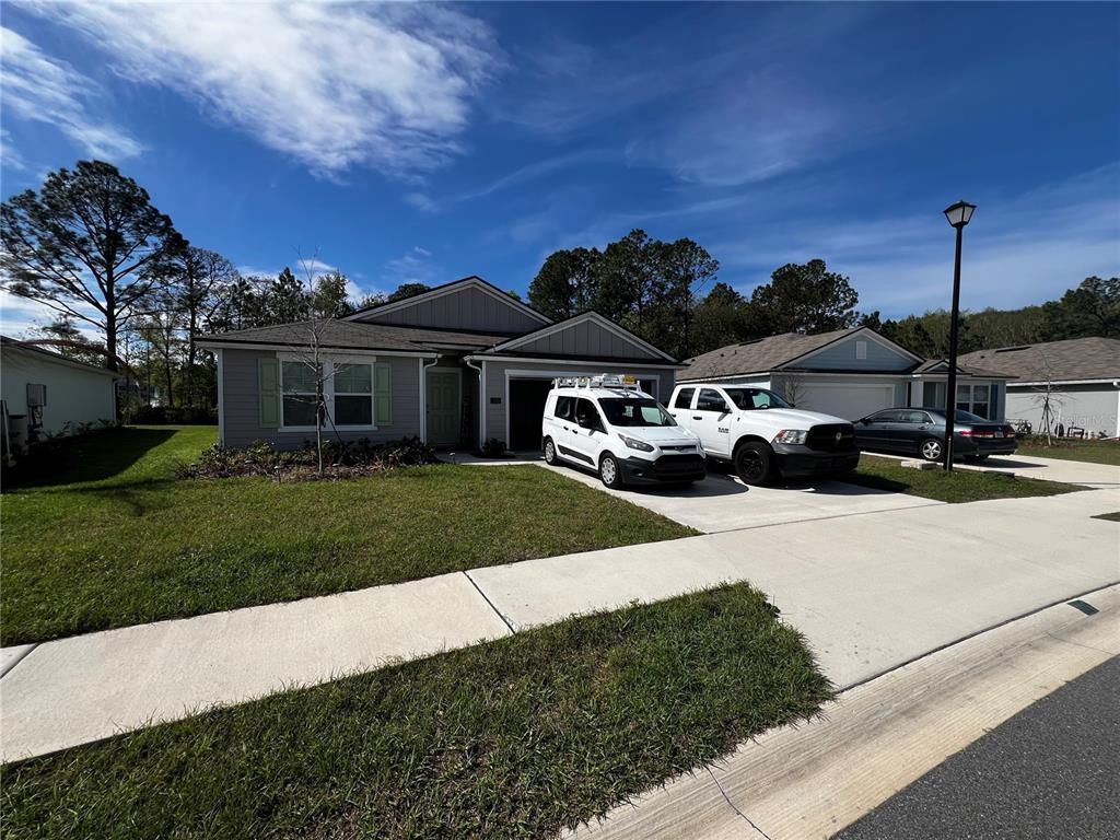 A single-story house with a gray exterior, a two-car garage, and a driveway with vehicles — 319 ARDILA CIRCLE, ST AUGUSTINE, FL