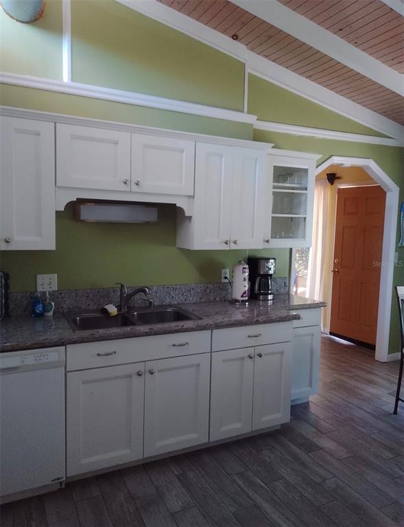 A kitchen features white cabinets, granite countertops, a double sink, and light green walls — 9434 BEAR LAKE ROAD, APOPKA, FL
