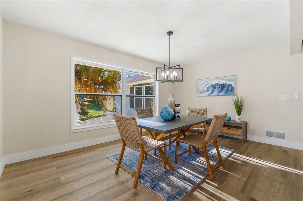 A living room features vaulted ceilings with exposed beams, a stone fireplace, and wood flooring — 5391 NW 76TH COURT, OCALA, FL