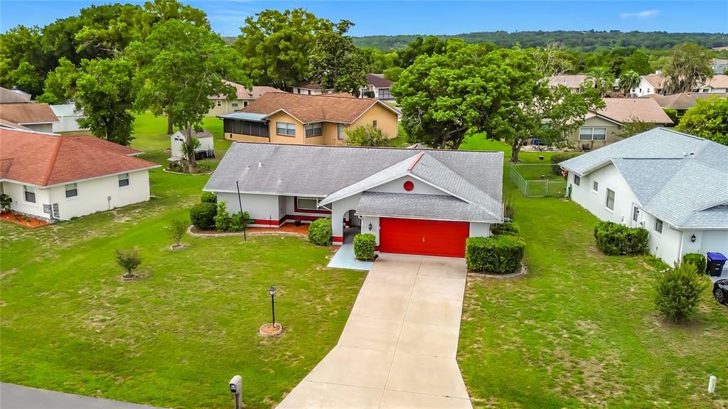 An aerial view of a single-story house with a red garage door and gray roof — 230 W STAGGERBUSH PATH, BEVERLY HILLS, FL