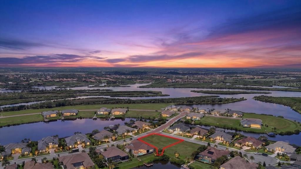 An aerial view shows a vacant residential lot outlined in red within a waterfront community — 11404 HARBOURSIDE LANE, PARRISH, FL
