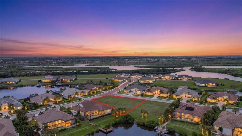 An aerial view shows a vacant residential lot outlined in red within a waterfront community — 11404 HARBOURSIDE LANE, PARRISH, FL