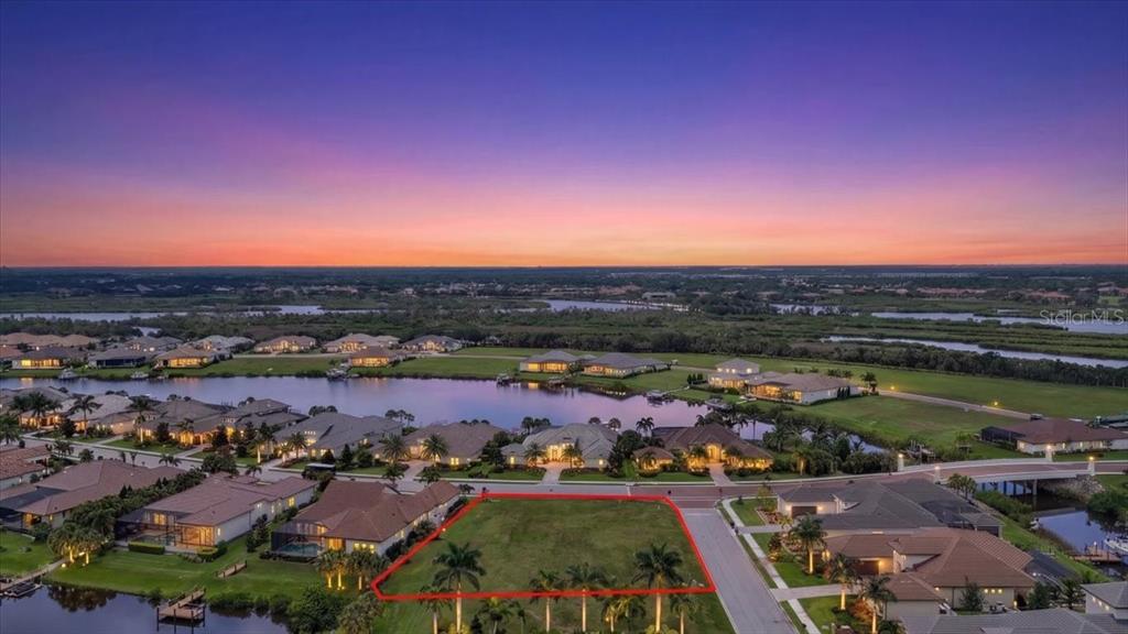 An aerial view shows a vacant residential lot outlined in red within a waterfront community — 11404 HARBOURSIDE LANE, PARRISH, FL