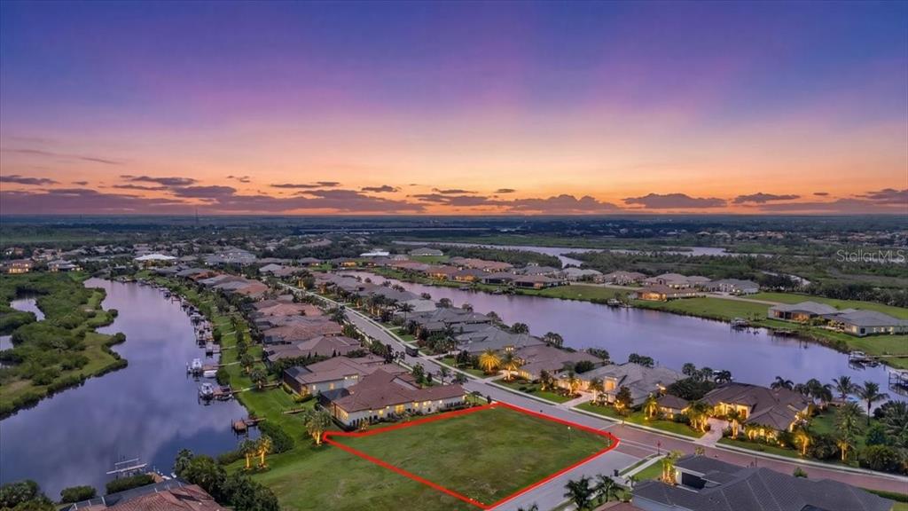 An aerial view shows a vacant residential lot outlined in red within a waterfront community — 11404 HARBOURSIDE LANE, PARRISH, FL