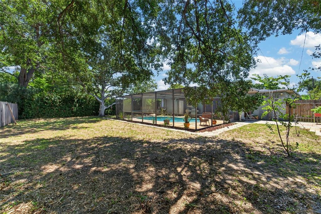 A screened-in swimming pool with a concrete deck and a grill on a backyard patio — 5825 20TH AVENUE S, GULFPORT, FL