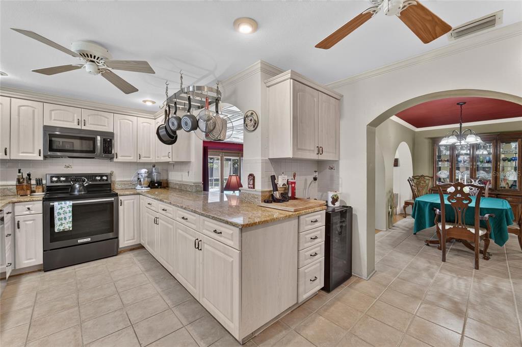 A backyard features a screened-in swimming pool, mature trees, and a wooden fence — 5825 20TH AVENUE S, GULFPORT, FL