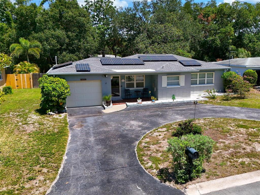 A kitchen with light wood cabinets, granite countertops, and a dining area visible through an archway — 5825 20TH AVENUE S, GULFPORT, FL