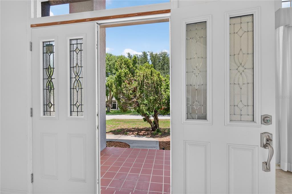 A view through an open double front door with decorative glass panels to a porch — 12608 LAKE RIDGE CIRCLE, CLERMONT, FL