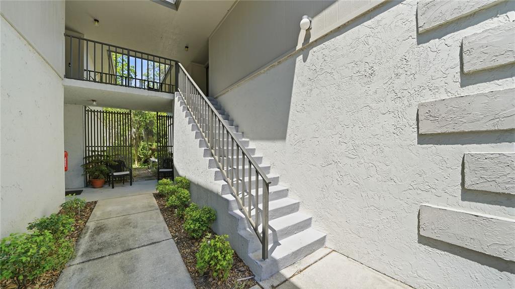 An exterior view of a concrete staircase leading to an upper-level balcony and walkway — 32 NAVARRA COURT, ST AUGUSTINE, FL