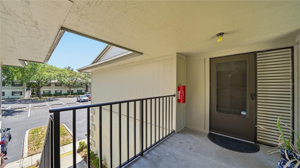 An exterior balcony with a metal railing overlooks a parking lot and apartment building — 32 NAVARRA COURT, ST AUGUSTINE, FL