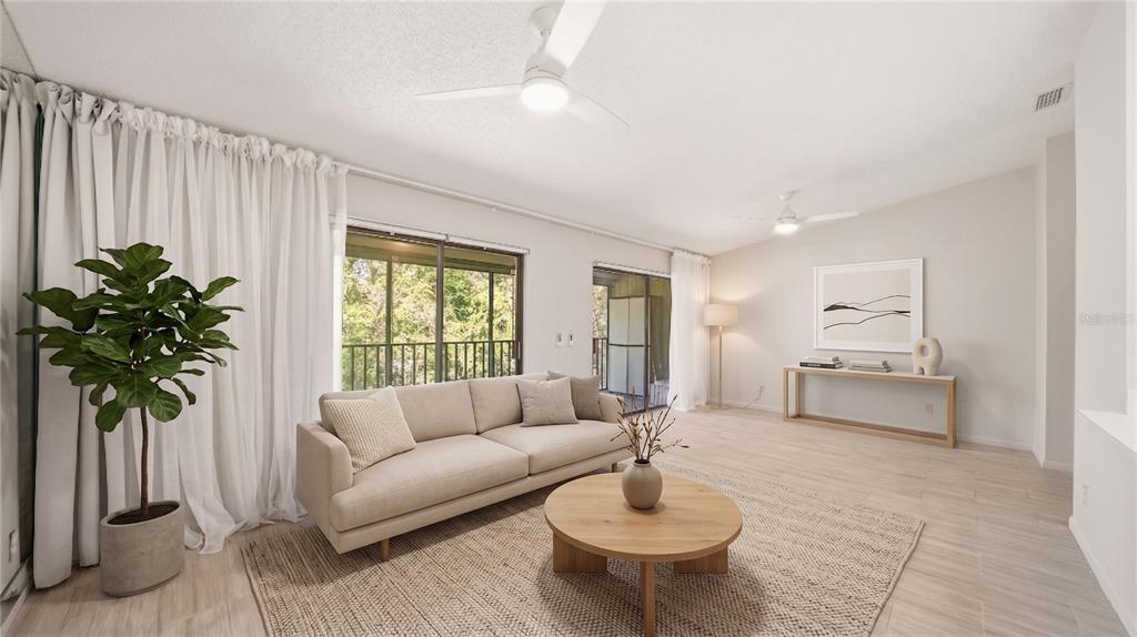 A bright living room features a beige sofa, round wooden coffee table, and sliding glass doors — 32 NAVARRA COURT, ST AUGUSTINE, FL