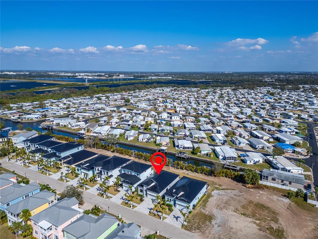 An aerial view shows a modern house with a dark roof in a residential neighborhood — 6540 SIMONE SHORES CIRCLE, APOLLO BEACH, FL