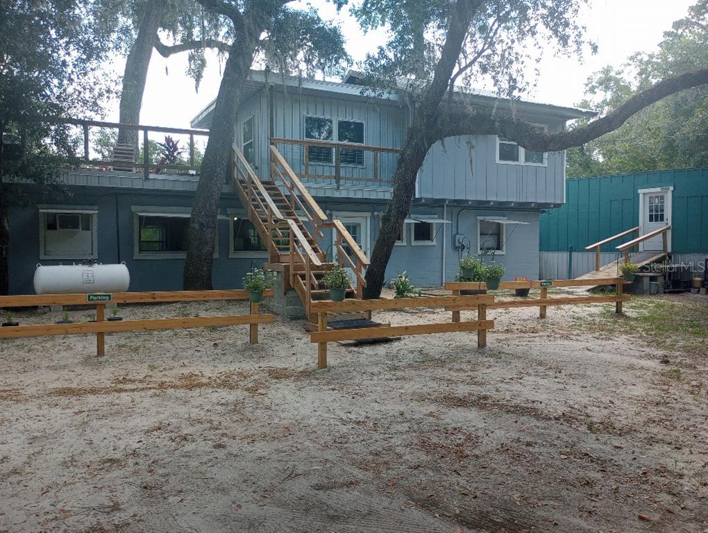 A two-story house with a wooden staircase leading to an upper deck and a fence — 348 NW NULL ROAD, WHITE SPRINGS, FL