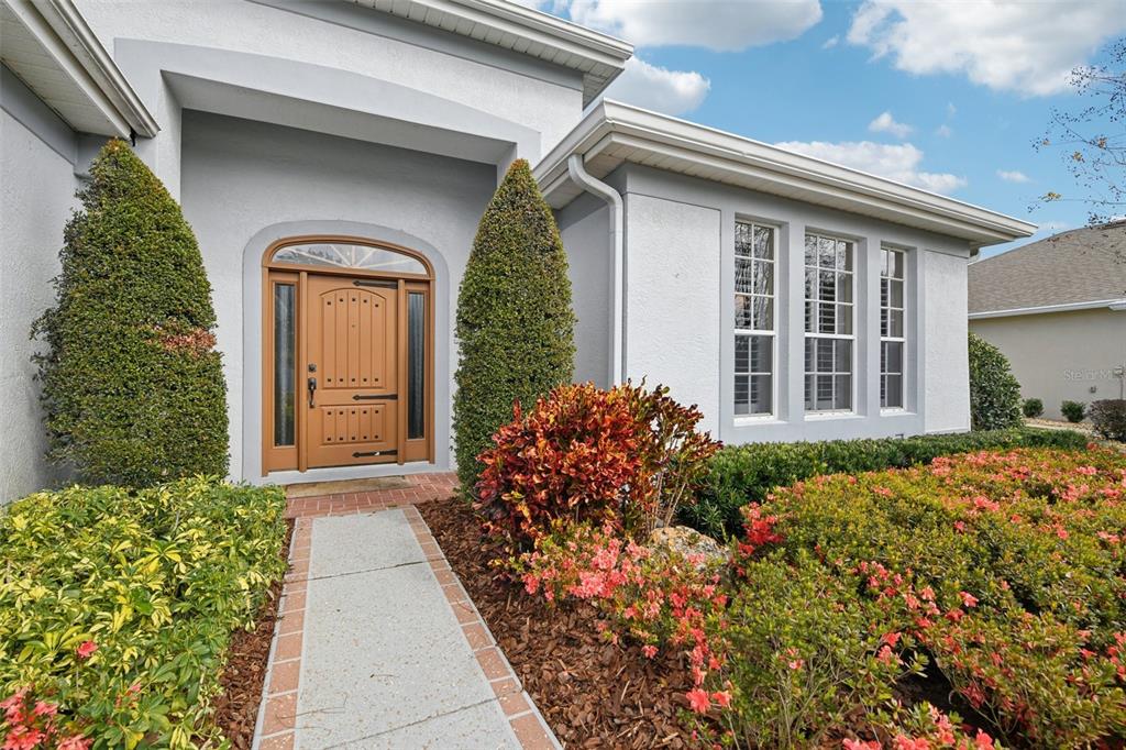A single-story house with a white exterior, a two-car garage, and a landscaped front lawn — 8013 PINE HOLLOW DRIVE, MOUNT DORA, FL
