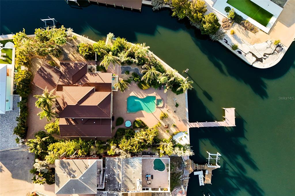 An aerial view shows a waterfront house with a pool, dock, and surrounding landscaping — 518 58TH STREET, HOLMES BEACH, FL