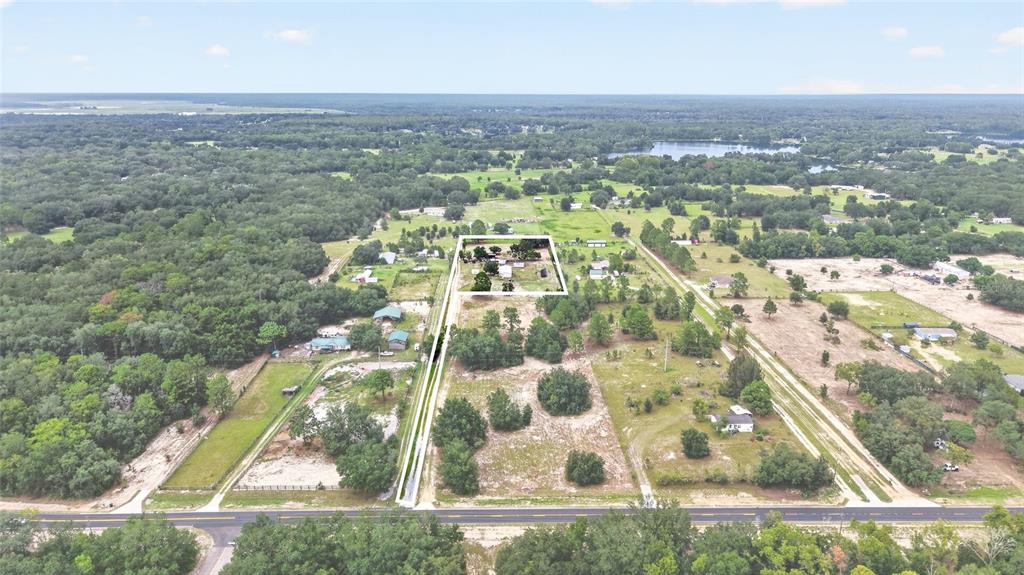 An aerial view shows a rural property with a house and outbuildings outlined in white — 15355 SE 113TH STREET ROAD, OCKLAWAHA, FL