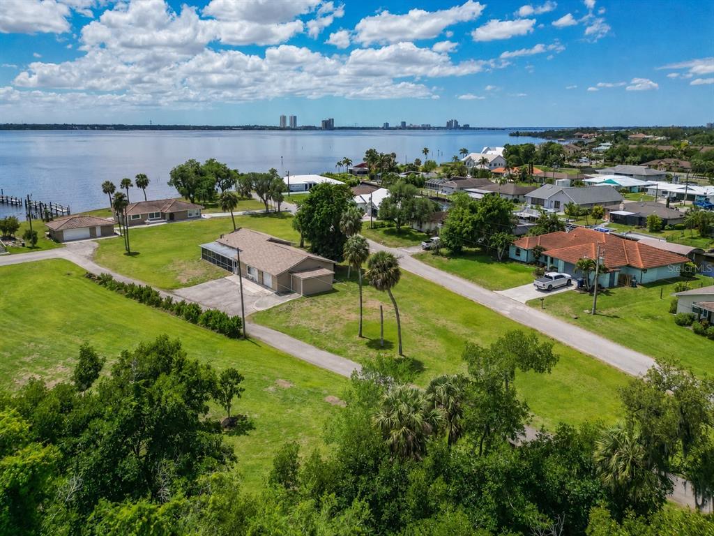 An aerial view shows several houses situated on a large grassy lot near a lake — 1818/1822 STEVENSON ROAD, NORTH FORT MYERS, FL