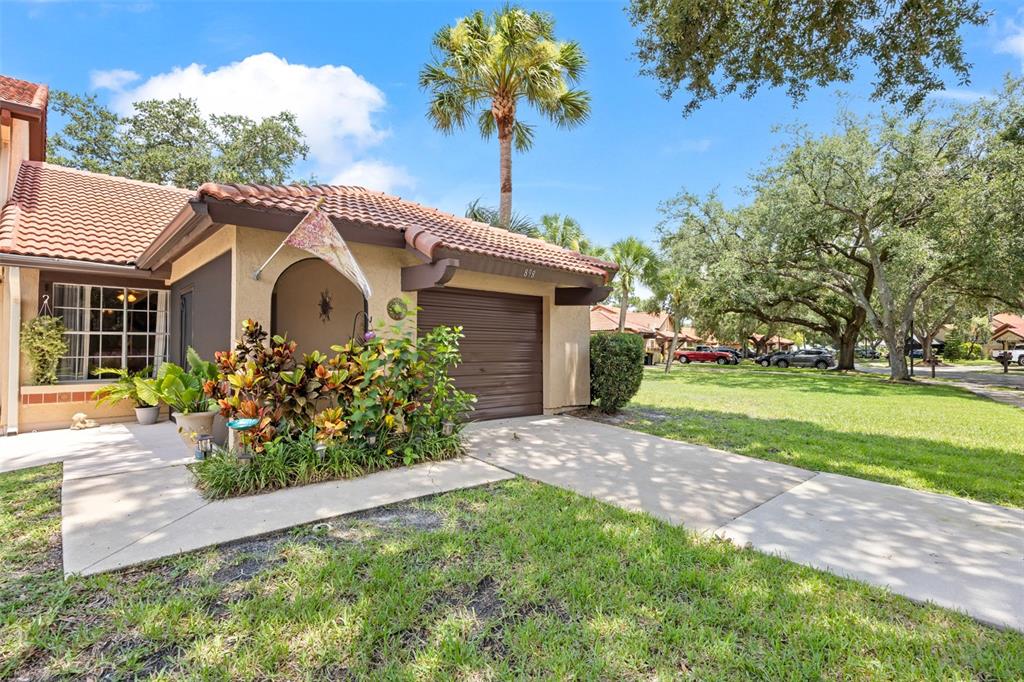 A single-story house with a brown garage door, tile roof, and landscaped front yard — 898 BROW COURT NE, PALM BAY, FL