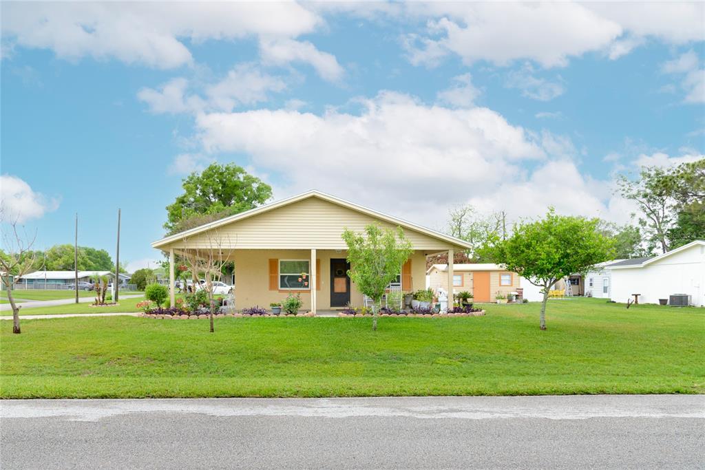 A single-story house with a covered front porch sits on a grassy lawn — 2300 3RD STREET, ST CLOUD, FL