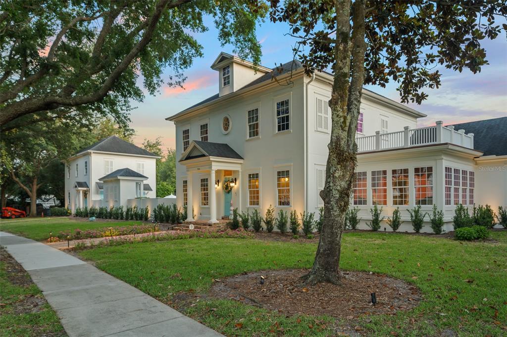 A two-story white house with a front porch, dormer window, and an attached side structure — 706 GOLFPARK DRIVE, CELEBRATION, FL