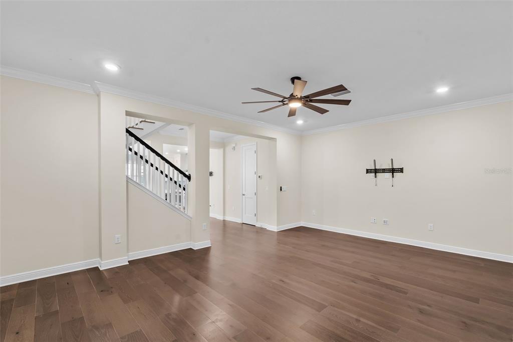 An empty living room features hardwood floors, a ceiling fan, and a staircase with railings — 404 S MELVILLE AVENUE UNIT 4, TAMPA, FL