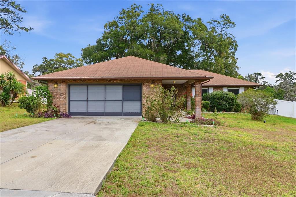 A single-story brick house with a brown shingled roof and a concrete driveway — 3265 NE 30 COURT, OCALA, FL